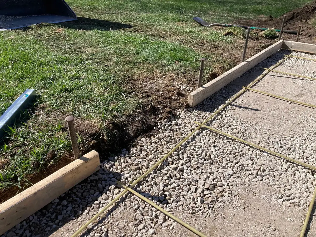 Wood forms and wire mesh set on a gravel base, ready to pour a concrete walk