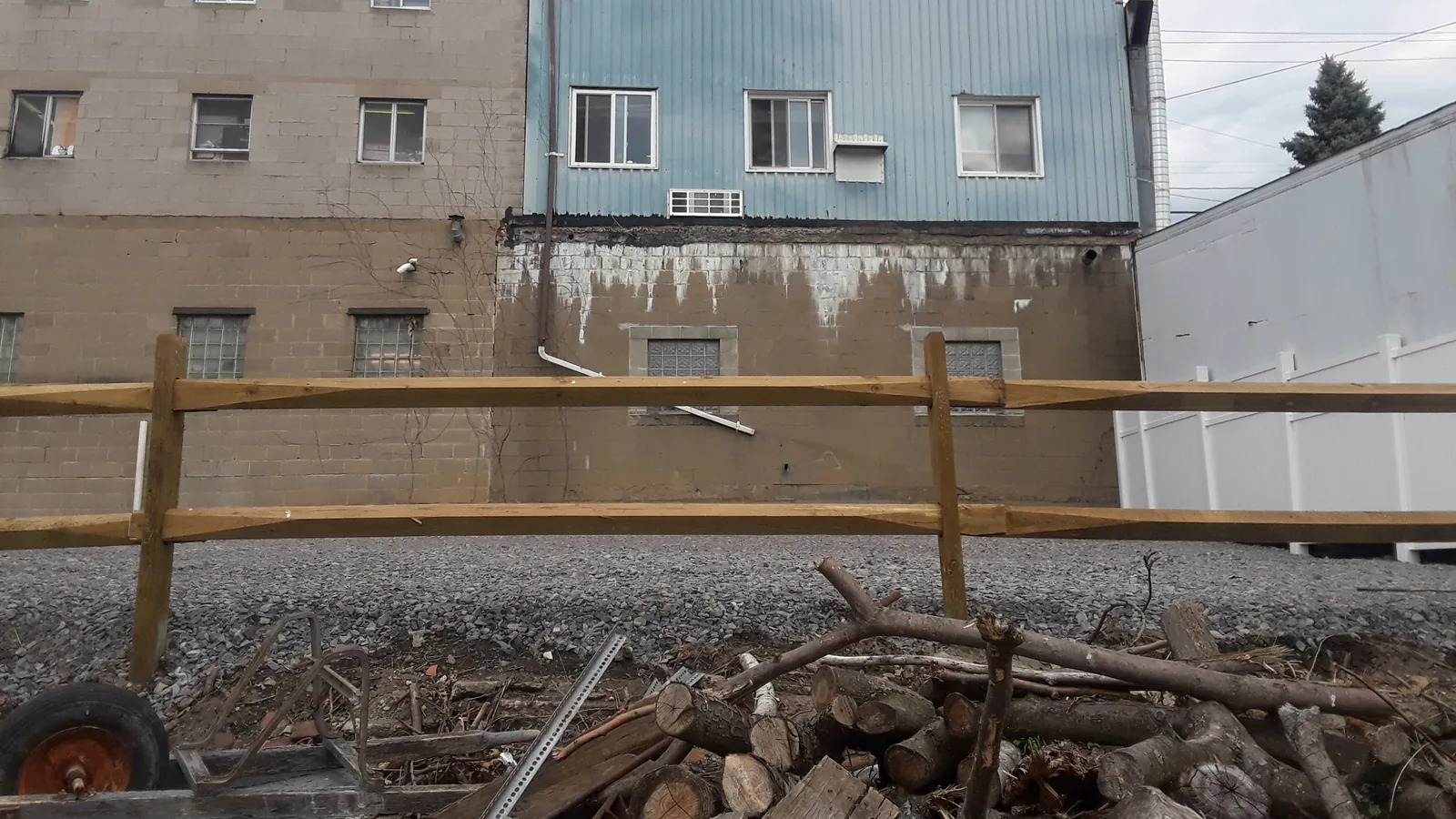 Cleared commercial yard with cut timber and scrap metal piled for hauling