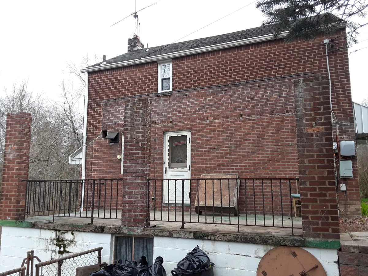 Rear of a two-storey brick house before demolition
