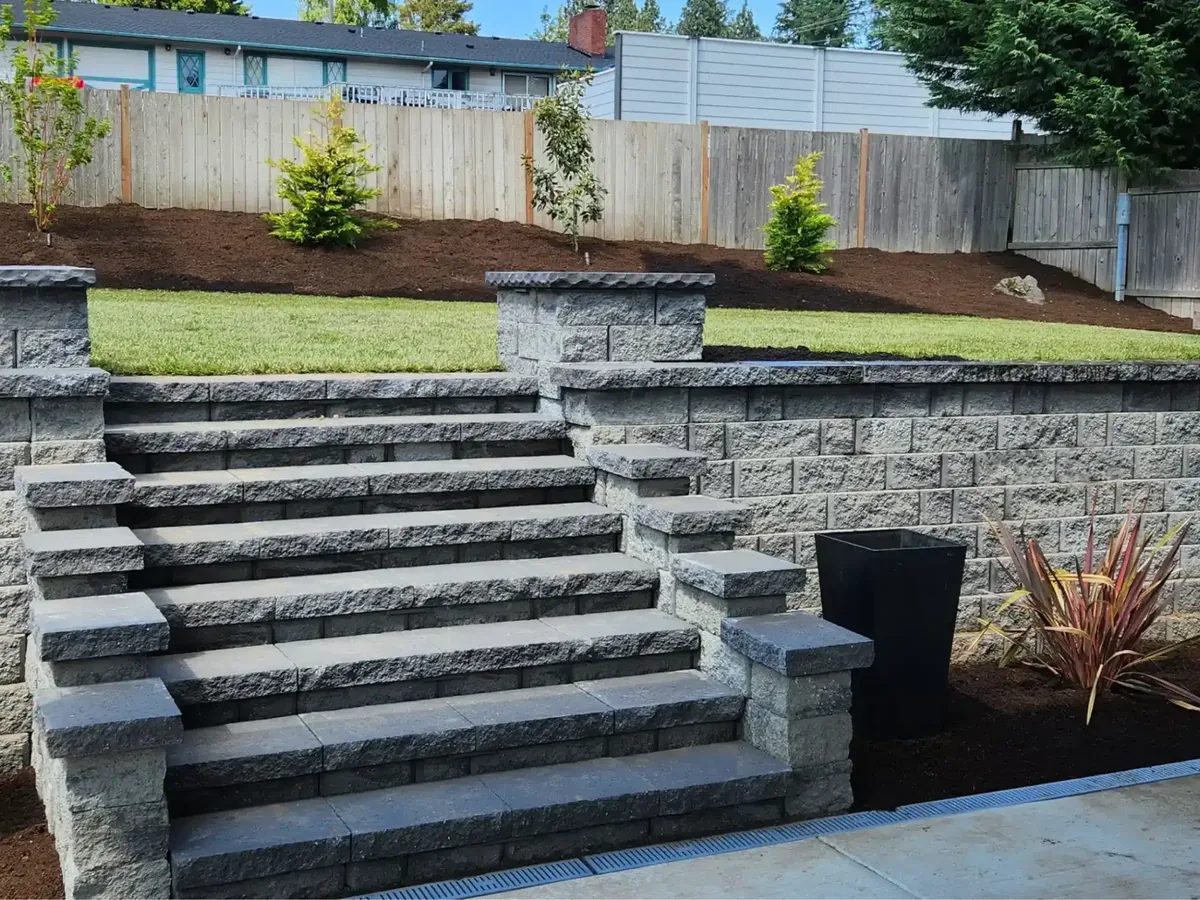 Segmental concrete block retaining wall with block steps built into a back yard